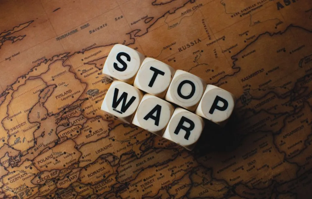 Dé avec inscription Stop War sur carte du monde vintage symbolisant les tensions géopolitiques