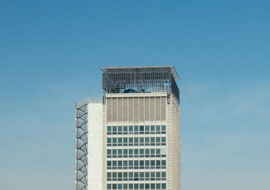 Tour de bureaux aux façades claires sous un ciel bleu