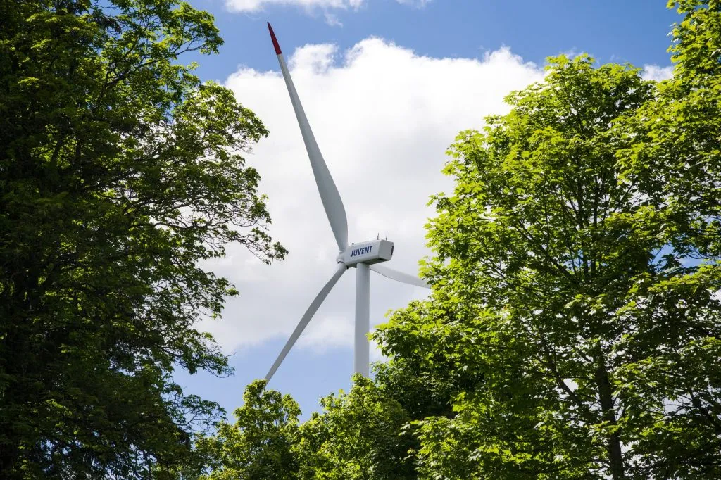 Éolienne dans une forêt verte, symbole de l’énergie renouvelable d’Engie