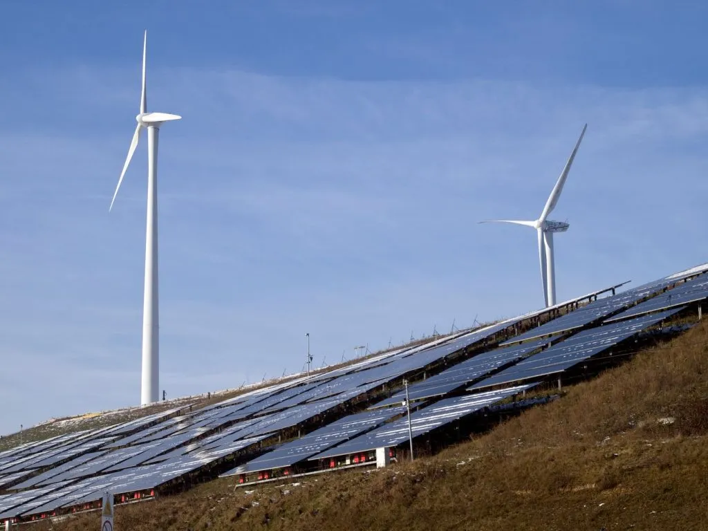 Éoliennes et panneaux solaires sur une colline, mix énergétique