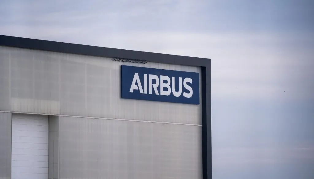 Façade d'un hangar Airbus avec le logo de la marque sur fond de ciel gris