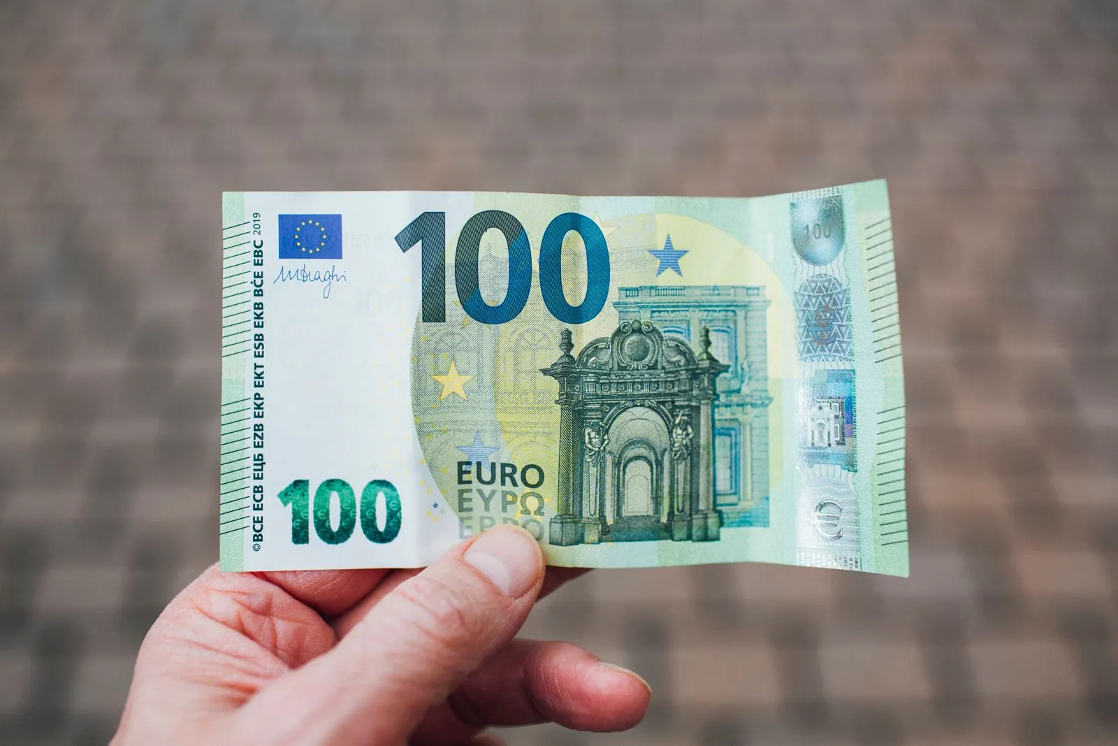 Main tenant un billet de 100 euros