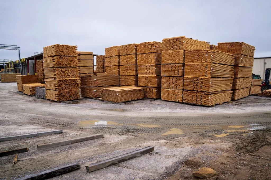 Piles de planches de bois prêtes à être distribuées sur un site industriel