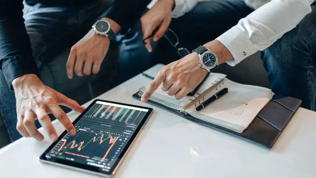 Consultants analysant des graphiques boursiers sur une tablette
