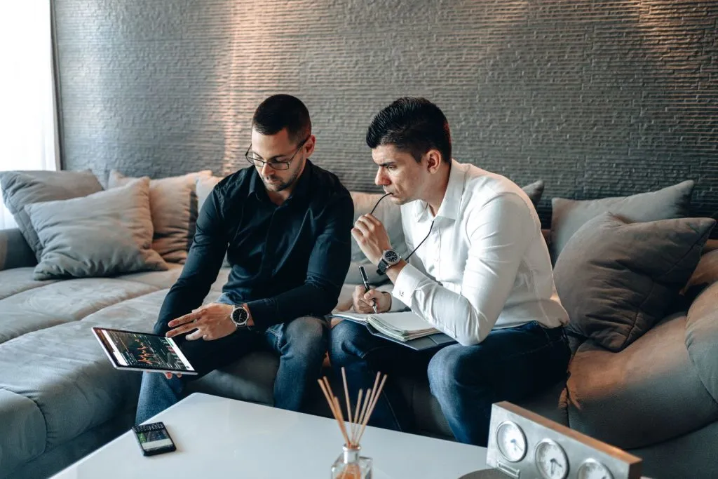Professionnels analysant des graphiques financiers sur une tablette numérique