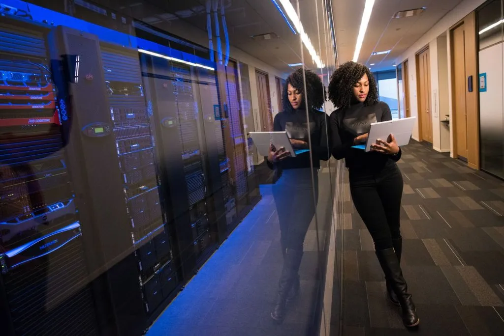 Femme utilisant un ordinateur portable dans un data center, le modèle récurrent représente 81% du chiffre d'affaires logiciel